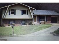 Charming home featuring a well-manicured lawn and a classic brick facade at 8778 Homewood Ct, Riverdale, GA 30274