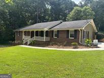 Charming brick home with a well-manicured lawn and inviting front porch perfect for relaxing at 2202 Springdale Dr, Snellville, GA 30078