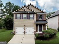 Charming two-story home with a two-car garage, well-maintained lawn, and purple shutters at 9132 Overlook Dr, Jonesboro, GA 30238