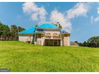 View of the rear exterior of the large two-story house with a large grassy area at 145 Windy Ridge Ct, Fayetteville, GA 30214