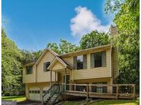Charming two-story home with a front porch, two-car garage and mature trees surrounding the property at 4014 Oak Stone Dr, Douglasville, GA 30135