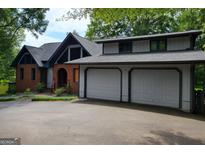 Charming two-story home featuring a two-car garage, brick accents and mature trees at 45 Surrey Chase Dr, Social Circle, GA 30025