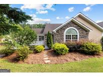 Charming home exterior with stone accents, complemented by lush landscaping and a welcoming pathway at 275 Rehobeth Way, Fayetteville, GA 30214