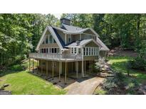 Charming two-story home with a large deck, surrounded by lush greenery and a well-maintained yard at 390 Stoneridge Way, Fayetteville, GA 30215