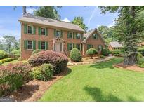 Charming brick home featuring a well-manicured lawn and vibrant green shutters at 829 Bev Ct, Lawrenceville, GA 30046