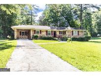 Charming brick home with a well-manicured lawn and covered parking at 650 Lynhurst Sw Dr, Atlanta, GA 30311