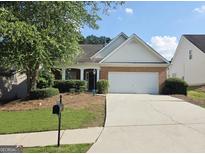 Charming one-story home with brick facade, manicured lawn, and attached two-car garage at 537 Goldfinch Way, Stockbridge, GA 30281