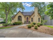 Charming stucco home featuring a red front door, mature trees, and a well-manicured lawn at 110 Tamerlane, Peachtree City, GA 30269
