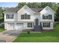 Charming two-story home features a two-car garage, landscaped yard, and welcoming front porch at 128 Southern Magnolia Ln, Rex, GA 30273