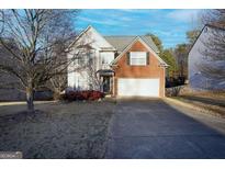 Two-story home featuring brick and vinyl siding, attached garage, and a well-manicured front yard at 860 Sweet Mill Ln, Lawrenceville, GA 30045