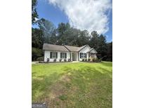 Charming single-story home with a well-maintained lawn and lush greenery at 60 Doe Run Dr, Sharpsburg, GA 30277