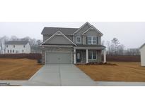 Charming two-story home with a gray facade, stone accents, and a well-manicured lawn at 6093 Ruby Fall, Stonecrest, GA 30038