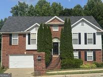 Charming two-story home with a brick facade, manicured landscaping, and an attached two-car garage at 393 Macland Dr, Lawerceville, GA 30045