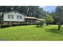 Charming home with a well-manicured lawn and mature trees offering shade and curb appeal at 3592 Charlotte Dr, Rex, GA 30273