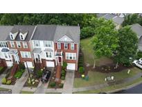 Beautiful townhomes boast brick facades, private garages, and landscaped front yards at 241 Balaban Cir # 241, Woodstock, GA 30188