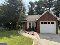 Charming brick home with a well-maintained lawn and an attached one car garage at 8113 Fieldstream Way, Douglasville, GA 30134