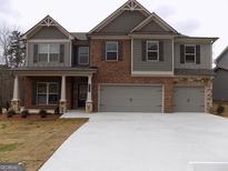 Charming two-story home featuring a brick and siding facade, a covered porch, and a spacious three-car garage at 1741 Cobblefield Cir, Dacula, GA 30019