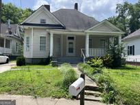 Charming, two-story home with a covered front porch and landscaped yard at 3155 E Point St, East Point, GA 30344