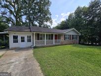 Charming single-story brick home with a covered front porch and a well-maintained lawn at 439 River Rd, Jonesboro, GA 30236