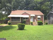 Charming brick home with a well-maintained lawn and covered porch, surrounded by mature trees at 1712 Clifton Se Way, Atlanta, GA 30316
