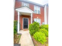 Charming brick townhome with a welcoming front entrance and a well-maintained landscaped yard at 5553 Strathmoor Manor Cir, Lithonia, GA 30058