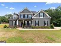 Charming two-story home with gray siding, black shutters, and a landscaped front yard at 935 S Laney Rd, Locust Grove, GA 30248