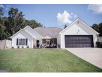Charming single-Gathering home featuring a well-maintained lawn, inviting front porch and two car garage at 401 N Lost Lake Cv, Villa Rica, GA 30180