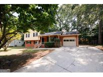 Charming two-story home featuring a well-maintained lawn, brick accents, and attached garage, perfect for suburban living at 500 Carillon Ct, Stone Mountain, GA 30083