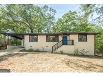 Charming single-story home featuring a blue front door, painted brick, a driveway and black trim at 3833 Bakers Ferry Sw Rd, Atlanta, GA 30331