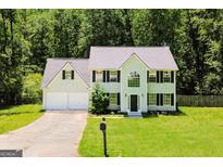 Charming two-story home with a well-manicured lawn, attached garage, and mature trees at 420 Callaway Pt, Mcdonough, GA 30252