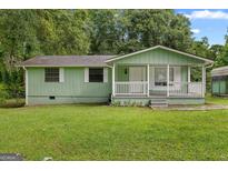 Charming one-story home with a welcoming front porch and well-maintained lawn at 107 Club Dr, Locust Grove, GA 30248