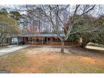 Charming brick home featuring a covered front porch and traditional design elements at 4225 Parkridge Dr, Powder Springs, GA 30127