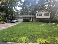 Charming two-story home with a well-manicured lawn and mature trees at 2663 Shiloh Hills Ct, Snellville, GA 30039