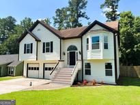 Charming two-story home featuring a welcoming entrance, attached garage, and well-manicured lawn at 5445 Maltdie, Sugar Hill, GA 30518