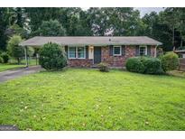 Charming one-story brick home featuring a covered front entrance and a well-manicured lawn at 6233 Castlewood Dr, Morrow, GA 30260