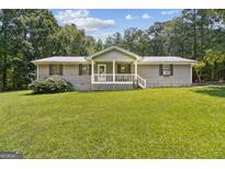 Charming single-story home with a welcoming front porch and expansive green lawn at 147 Pine St, Covington, GA 30014