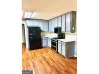 Stylish kitchen features stainless steel appliances, gray cabinetry and a beautiful stone backsplash at 398 Mckenzie Dr, Stockbridge, GA 30281