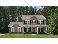 Charming two-story home featuring a welcoming front porch and a beautifully landscaped lawn with a basketball hoop at 85 Crabapple Ridge Dr, Oxford, GA 30054