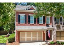 Charming two-story brick townhome with a two-car garage and beautifully landscaped front yard at 48 Star Spangled Ln, Peachtree City, GA 30269