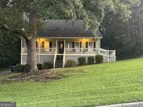 Charming single-story home with covered porch, mature trees, and well-manicured lawn at 375 Big Game Way, Loganville, GA 30052