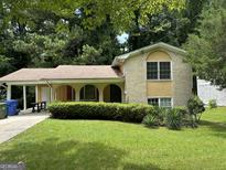 Charming home with a brick facade, arched entryways, and a well-maintained lawn surrounded by mature trees at 273 Fennel Sw Way, Atlanta, GA 30331
