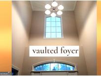 Bright foyer featuring a high vaulted ceiling, transom windows, and decorative lighting fixture at 30 Cynthia Ct, Fayetteville, GA 30215