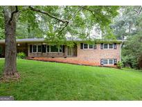 Charming brick home featuring a well-manicured lawn and a cozy front porch at 4852 Pine Shadows, Stone Mountain, GA 30088