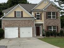 Beautiful two-story home featuring a two-car garage, brick accents, and manicured landscaping at 4199 Elderberry Nw Dr, Acworth, GA 30101