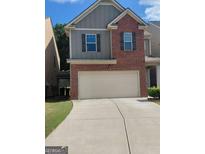 Two-story home with a brick and siding exterior, a two-car garage, and a well-maintained lawn at 1945 Labonte Pkwy # 42, Mcdonough, GA 30253