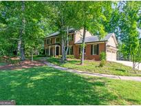 Traditional brick home featuring a well-manicured lawn and mature trees at 200 Savannah Walk, Peachtree City, GA 30269