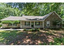 Charming single-story home featuring a stone facade, inviting front porch and nicely landscaped front yard at 380 Peach Drive, Mcdonough, GA 30253