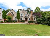Stately brick home featuring manicured lawn, mature trees and decorative stone accents at 1360 Mount Mckinley Dr, Grayson, GA 30017