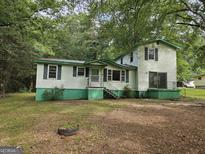 Two-story home featuring green trim and shutters, surrounded by mature trees at 125 Rosenwald Cir, Stockbridge, GA 30281