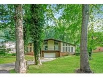 Two-story home featuring lush landscaping, a brick base, and a two-car garage at 6290 Shallowford Way, Douglasville, GA 30135
